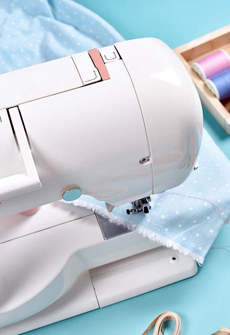 sewing machine sewing blue fabric for a quilt